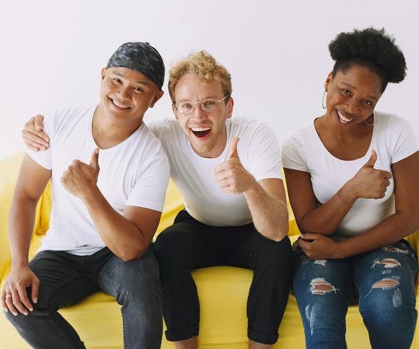 Diverse group of people smiling in a bright yoga studio.